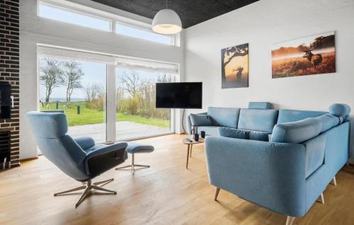 a living room with blue chairs and a tv at Awesome Home In Thyholm With Wifi in Thyholm