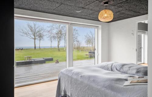 a bedroom with a bed and a large window at Awesome Home In Thyholm With Wifi in Thyholm