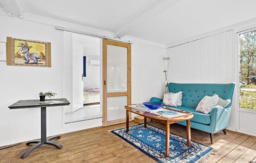 a living room with a blue couch and a table at 1 Bedroom Beautiful Home In Tikøb in Tikøb