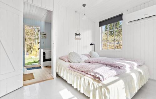 een witte slaapkamer met een groot bed met kussens bij 1 Bedroom Stunning Home In Tikb in Tikøb