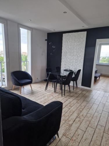 - un salon avec une table et des chaises noires dans l'établissement Apartament XIII piętro STADION NARODOWY, à Varsovie