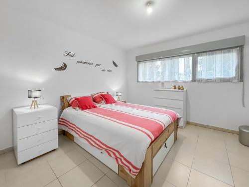 a white bedroom with a large bed with red pillows at Vivez Lunel-Clim-Wifi Fibre-Parking Privé-Patio T2 in Lunel