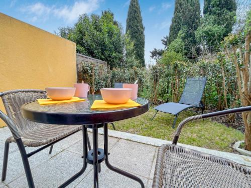 a table with two bowls on top of a patio at Vivez Lunel-Clim-Wifi Fibre-Parking Privé-Patio T2 in Lunel