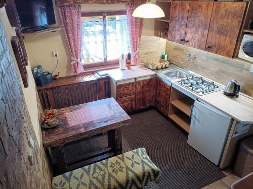 a small kitchen with a sink and a stove at Yellow Paradise House in Hrabušice