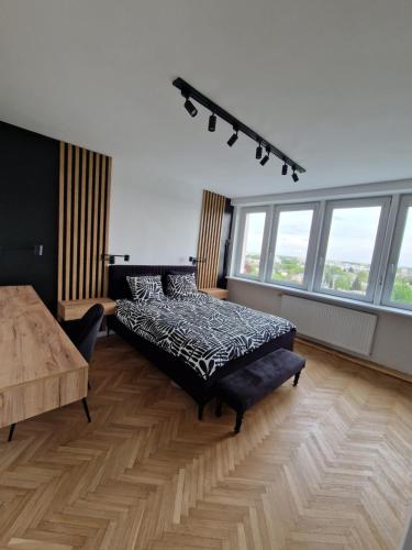 - une chambre avec un lit, un canapé et des fenêtres dans l'établissement Apartament XIII piętro STADION NARODOWY, à Varsovie