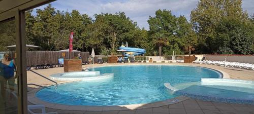 a large swimming pool with a woman standing next to it at Mobilhome L'Oasis Camping le Clos Cottet in Angles