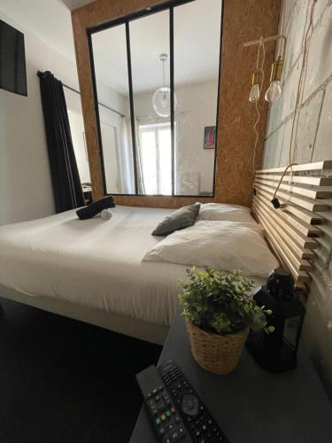 - une chambre avec un lit et un grand miroir dans l'établissement La Grande Madeleine, à Nantes