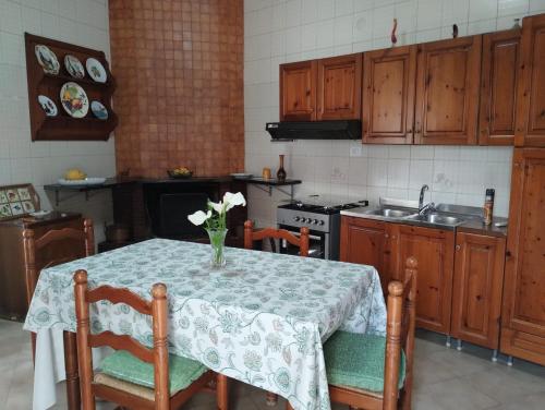 una cucina con tavolo e vaso di fiori di The Middle House a Castellammare di Stabia