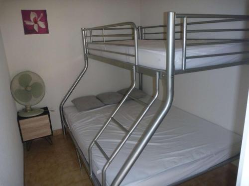 quelques lits superposés dans une chambre dans l'établissement Appartement 2 pièces avec accès direct plage, terrasse et parking - FR-1-387-146, au Cap d'Agde