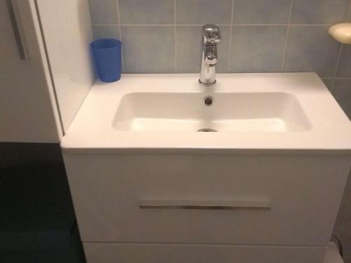 La salle de bains est pourvue d'un lavabo blanc et d'un robinet. dans l'établissement Appartement 2 pièces avec accès direct plage, terrasse et parking - FR-1-387-146, au Cap d'Agde