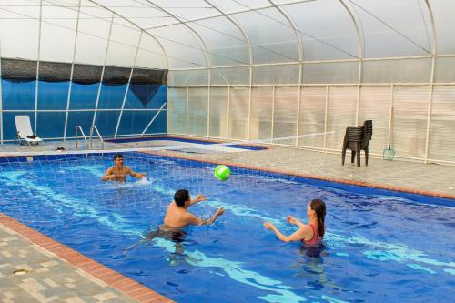 een groep mensen in een zwembad met een bal bij Finca cafetera turística in Buesaco