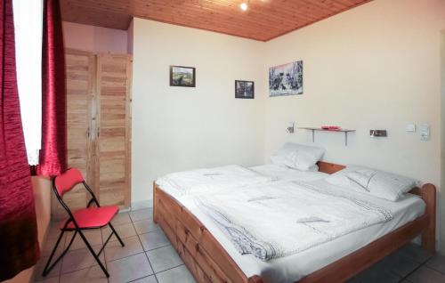 ein Schlafzimmer mit einem Bett und einem roten Stuhl in der Unterkunft Ferienhaus Am Rodelberg H in Priborn