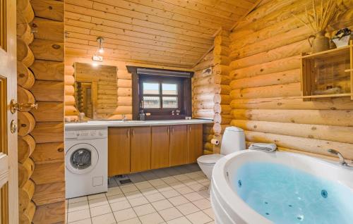 ein Blockhausbad mit einer Badewanne und einer Waschmaschine in der Unterkunft Amazing Home In Fjerritslev With Wifi in Fjerritslev