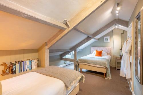 a attic bedroom with two beds and a book shelf at 30 Frenchgate in Richmond