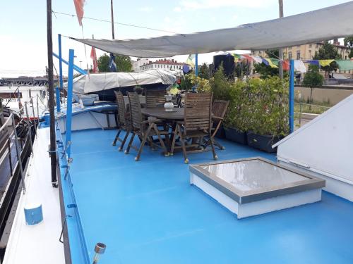 une table et des chaises sur le pont d'un bateau dans l'établissement peniche l oiseau bleu, à Lyon