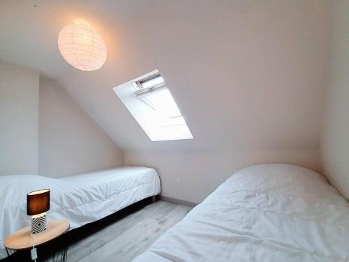 une chambre avec deux lits jumeaux et une fenêtre dans l'établissement Maison à Carnac, proche plage, jardin clos, 3 pièces, 4 pers, Wifi, parking, petit animal accepté - FR-1-477-154, à Carnac