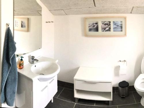 a white bathroom with a sink and a toilet at Holiday home Bagenkop VII in Bagenkop