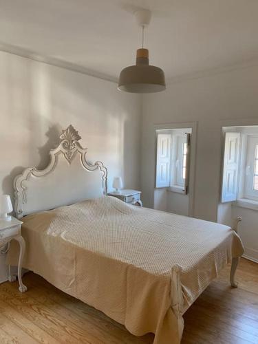 a bedroom with a large white bed in a room at Casa do Mestre João in São Martinho