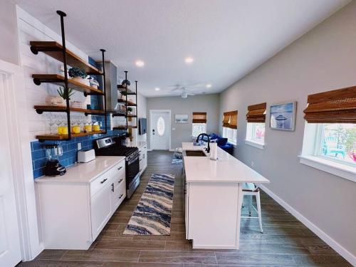 Una cocina grande con gabinetes blancos y encimera. en Hidden Beach Bungalow, en New Smyrna Beach