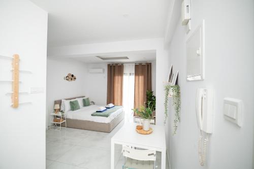 a white living room with a bed and a table at Quattro City Center Ap 501B in Larnaka