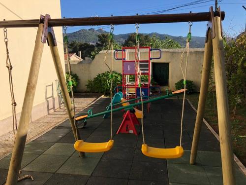 a playground with a swing set in a backyard at Casa do Mestre João in São Martinho