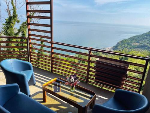 uma varanda com cadeiras e uma mesa e vista para o oceano em Baia Vallugola Exclusive Apartment em Castel di Mezzo