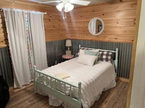 a bedroom with a bed with a wooden wall at Current River Getaway in Van Buren