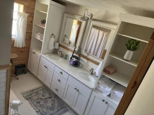 a bathroom with two sinks and two mirrors at Current River Getaway in Van Buren