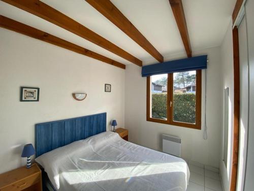 a bedroom with a blue bed and a window at Villa Capbreton, 4 pièces, 6 personnes - FR-1-413-114 in Capbreton