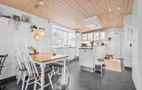 a kitchen with a wooden ceiling and a table and chairs at 2 Bedroom Beautiful Home In Esbjerg V in Esbjerg