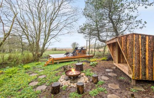 a small wooden house with a fire pit in a field at 2 Bedroom Beautiful Home In Esbjerg V in Esbjerg