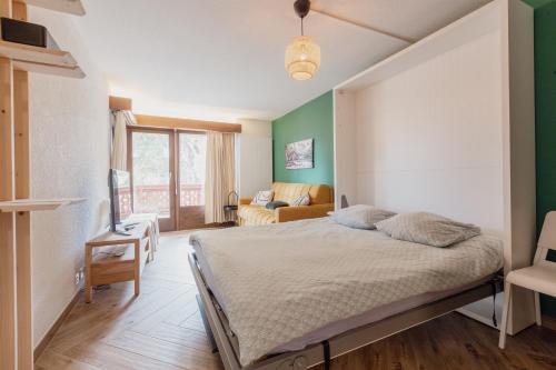 a bedroom with a bed and a living room at Cosy and modern apartment closed to the ski lift in Crans-Montana