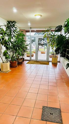 a room with potted plants and a tile floor at Studio Saint-Cyprien Port in Saint-Cyprien