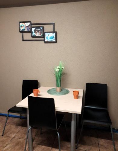 a table with four chairs and a vase of flowers on it at GO Hostel Rewolucji in Łódź