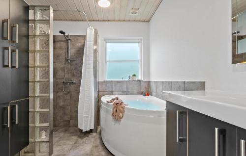 a white bathroom with a tub and a sink at Stunning Home In Haderslev With House Sea View in Haderslev