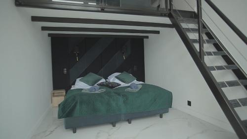 a bed with a green comforter in a room at Wiking in Władysławowo