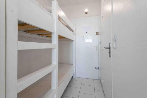 Cette chambre blanche dispose d'un placard et d'une porte. dans l'établissement Studio cabine vue mer centre port, au Cap d'Agde