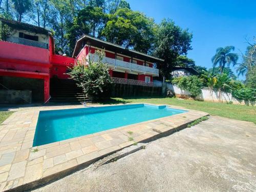 uma piscina em frente a uma casa em Chácara com Piscina e Amplo Quintal em Embu