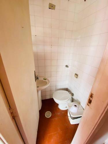 a small bathroom with a toilet and a sink at Chácara com Piscina e Amplo Quintal in Embu