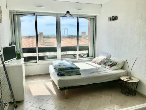 un lit assis dans une pièce avec une fenêtre dans l'établissement Studio cabine vue mer centre port, au Cap d'Agde