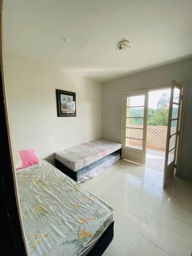 a room with two beds and a sliding glass door at Chácara com Piscina e Amplo Quintal in Embu