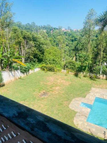 a view of a yard with a swimming pool at Chácara com Piscina e Amplo Quintal in Embu