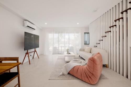 a living room with a couch and a tv at Netflix Brand new 4BR Fast NBN AC Free Parking in Gold Coast
