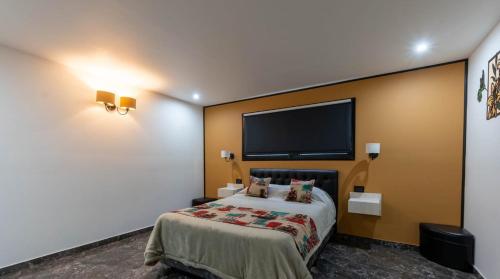 a hotel room with a bed and a flat screen tv at Casa Vida in Sierra de los Padres