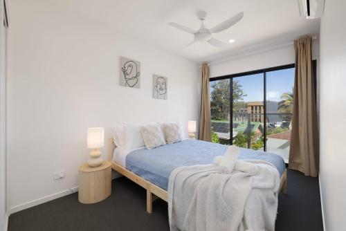 a bedroom with a bed and a large window at Netflix Brand new 4BR Fast NBN AC Free Parking in Gold Coast