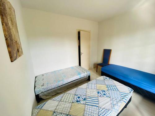 a room with two beds and a blue bedvisor at Chácara com Piscina e Amplo Quintal in Embu