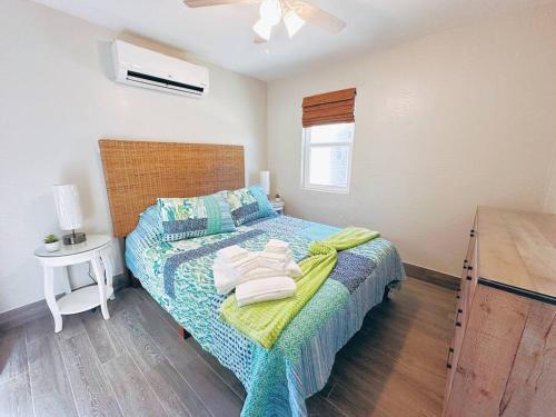 Un dormitorio con una cama con toallas. en Hidden Beach Bungalow, en New Smyrna Beach
