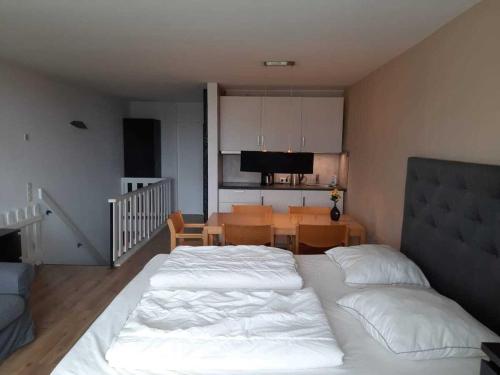 a bedroom with a bed and a dining room at Wald Apartments im Predigtstuhl Resort in Sankt Englmar