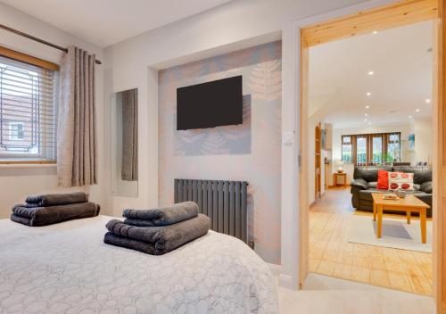 a bedroom with a bed and a tv on a wall at Malthouse Lodge in Heacham