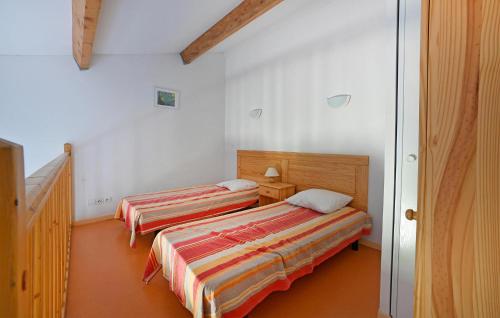 2 Betten in einem Zimmer mit weißen Wänden in der Unterkunft Nice Home In Calvisson With Kitchen in Calvisson